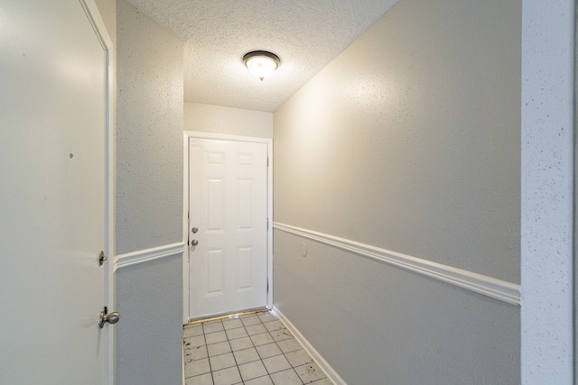 entryway featuring light tile floors and a textured ceiling