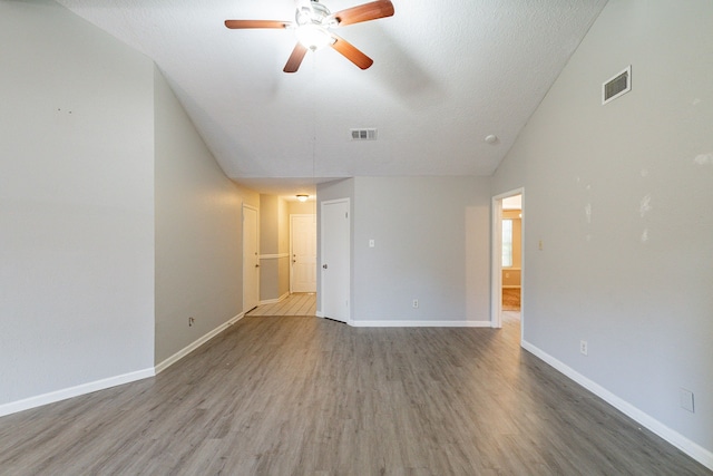 unfurnished bedroom with wood-type flooring, ceiling fan, vaulted ceiling, and a textured ceiling