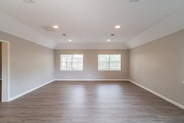 spare room with lofted ceiling and hardwood / wood-style flooring