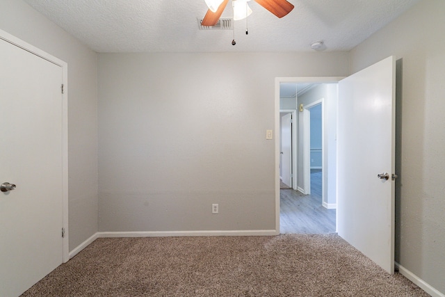 carpeted spare room with ceiling fan and a textured ceiling