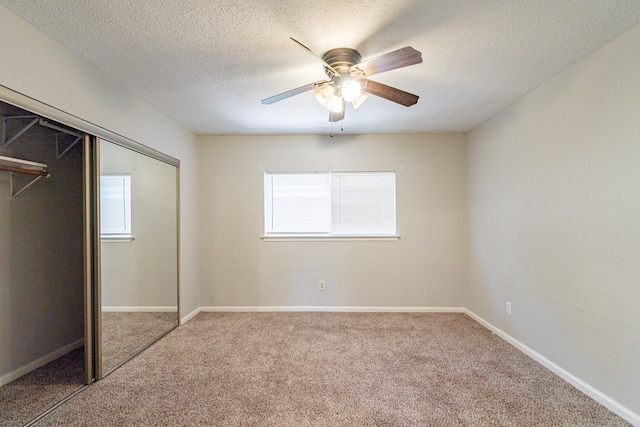 unfurnished bedroom with a closet, multiple windows, carpet, and ceiling fan