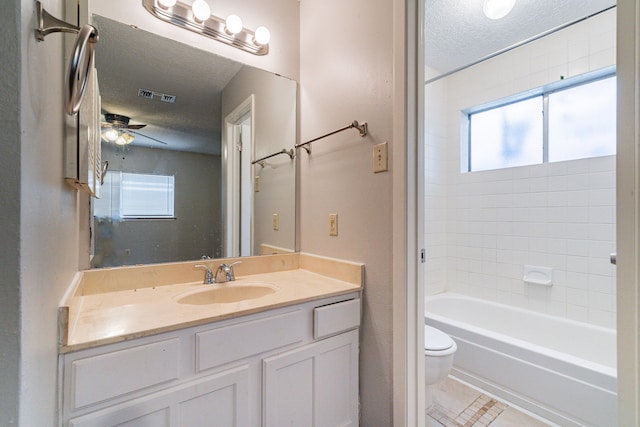 full bathroom with tile flooring, ceiling fan, a textured ceiling, oversized vanity, and toilet