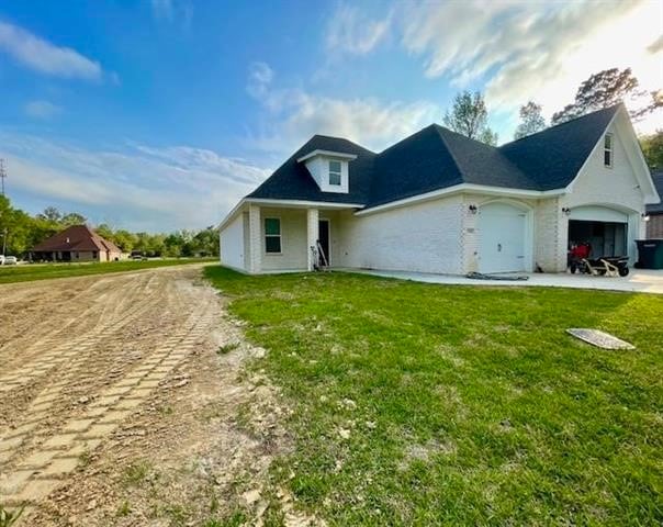 view of front of property featuring a garage and a front lawn