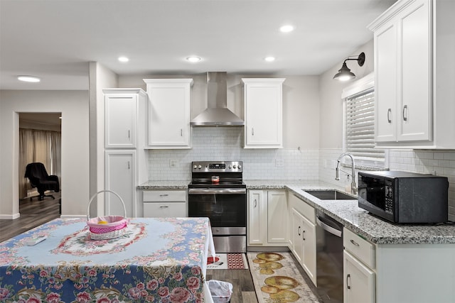 kitchen with tasteful backsplash, appliances with stainless steel finishes, wall chimney range hood, and dark hardwood / wood-style flooring