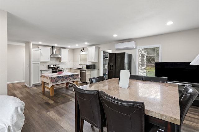 dining space featuring sink, dark hardwood / wood-style flooring, and a wall unit AC