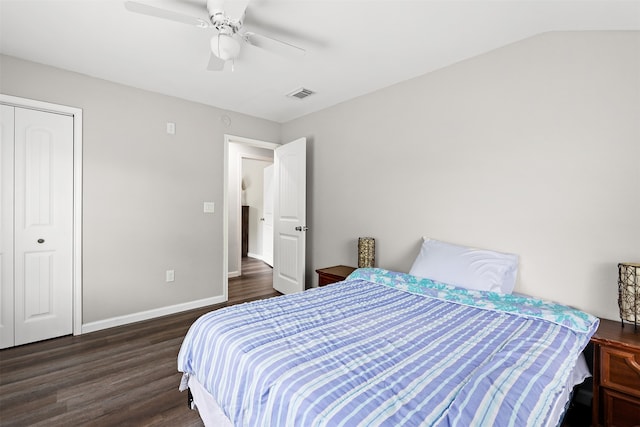 bedroom with a closet, ceiling fan, dark wood-type flooring, and vaulted ceiling