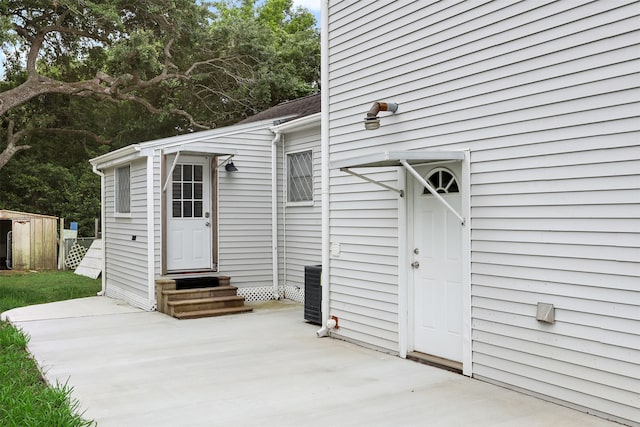 view of exterior entry featuring a patio area and central air condition unit