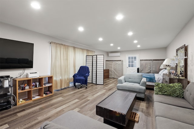 living room featuring hardwood / wood-style floors and a wall mounted air conditioner