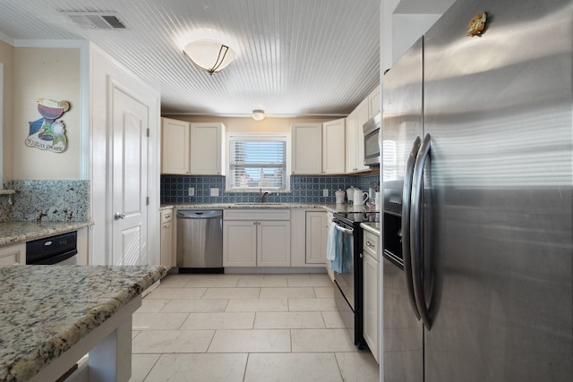 kitchen featuring appliances with stainless steel finishes, backsplash, light tile flooring, light stone counters, and sink