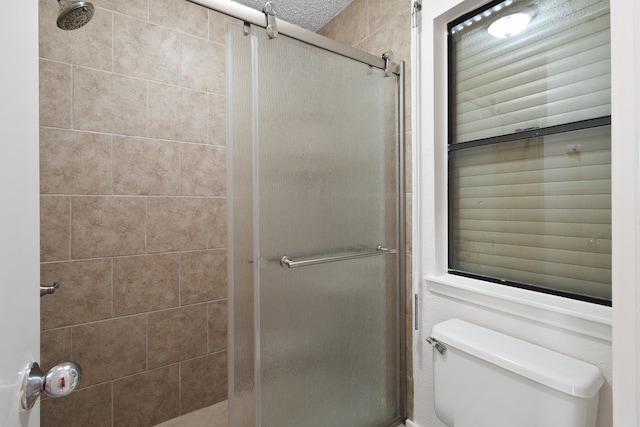 bathroom with an enclosed shower and toilet