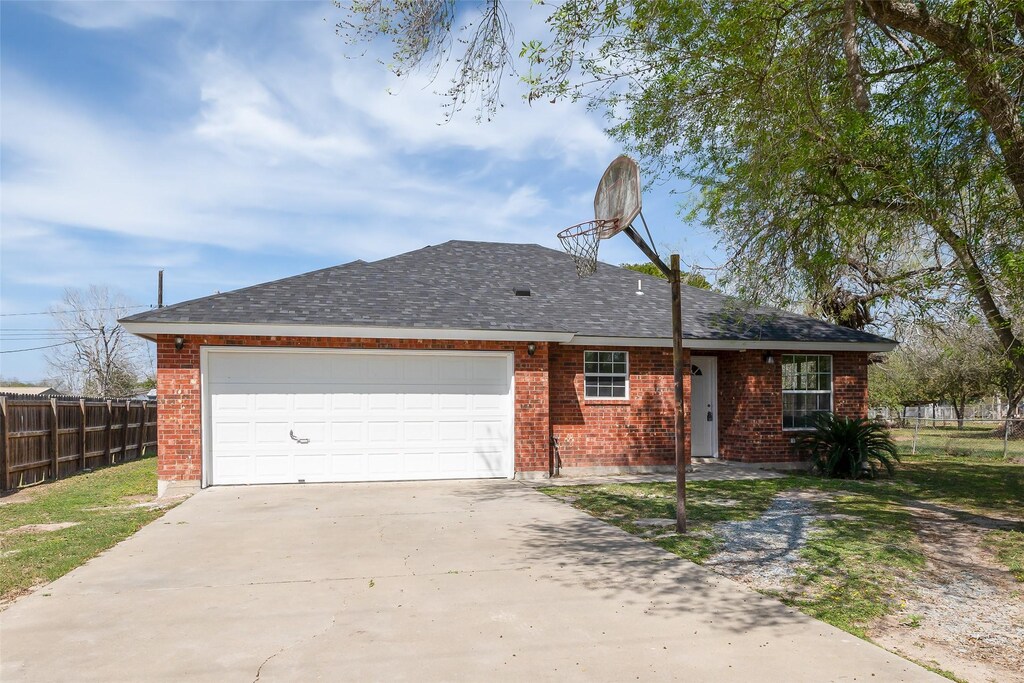 446 W Main St, Sebastian, TX 78569 - single story home featuring fence, driveway, an attached garage, and brick siding