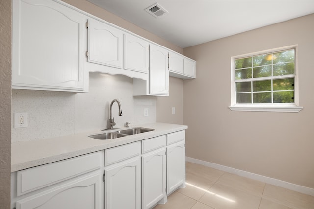 kitchen featuring white cabinetry, light tile patterned flooring, tasteful backsplash, and sink