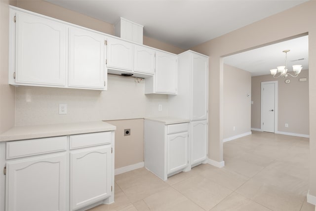 kitchen featuring white cabinetry, a chandelier, decorative light fixtures, and light tile patterned floors