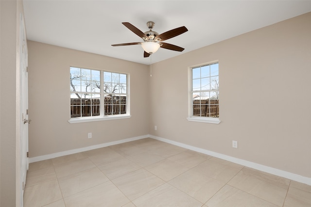 empty room with ceiling fan and light tile patterned flooring