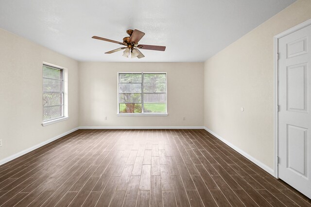 empty room with ceiling fan and dark wood-type flooring