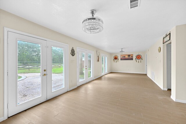 interior space with french doors and a chandelier