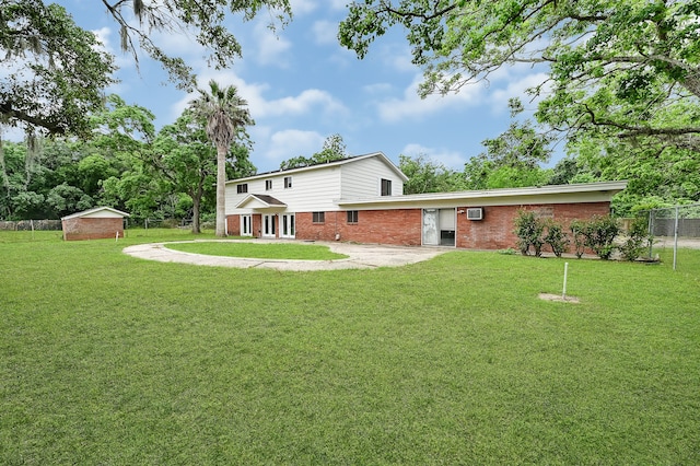 back of house featuring a yard and an outdoor structure