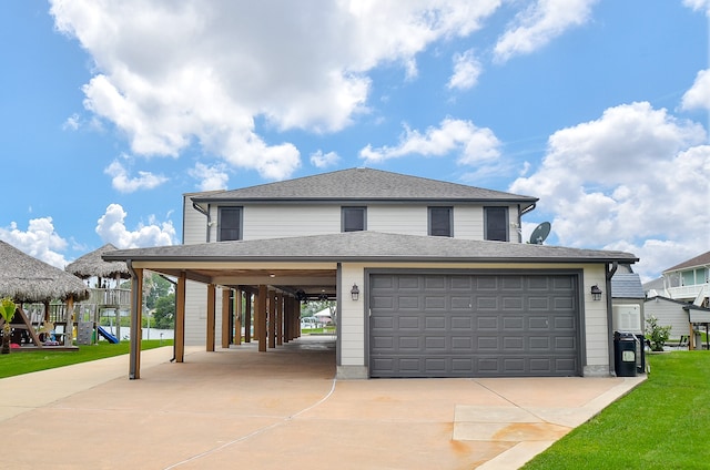 view of front of house with a front lawn, a carport, a playground, and a garage