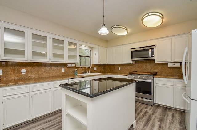 kitchen featuring a center island, pendant lighting, stainless steel appliances, and white cabinets