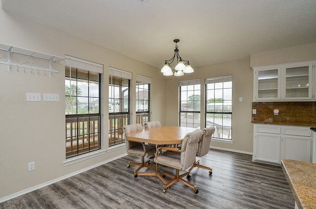 dining space featuring dark hardwood / wood-style flooring and a notable chandelier