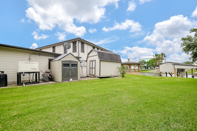 rear view of property with a storage unit and a lawn