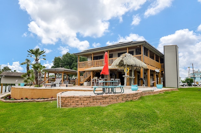 back of house with a patio area, a yard, and a balcony