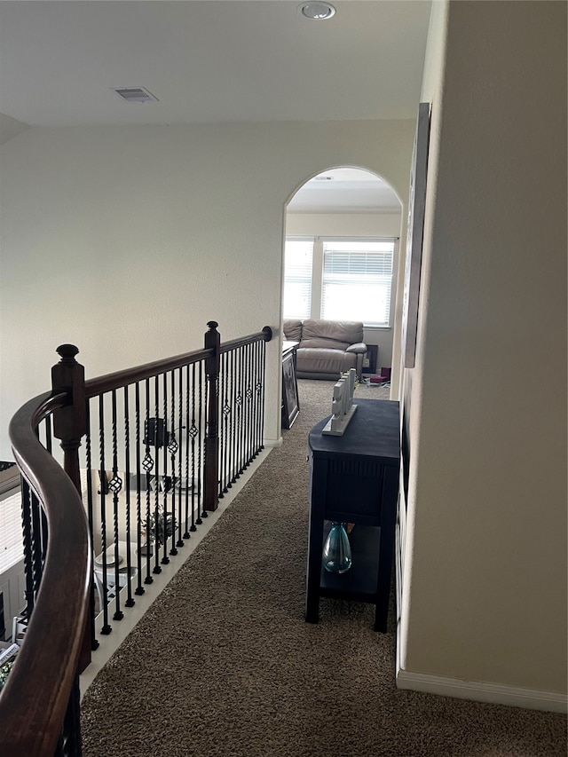 hall featuring dark colored carpet