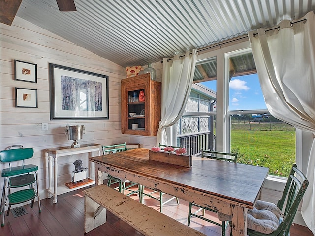 dining room with wood-type flooring, lofted ceiling, wooden ceiling, and wooden walls