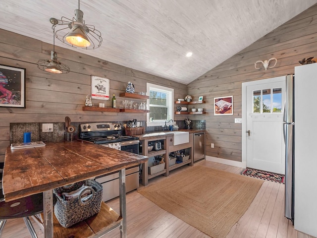 kitchen featuring stainless steel appliances, sink, light hardwood / wood-style floors, and vaulted ceiling