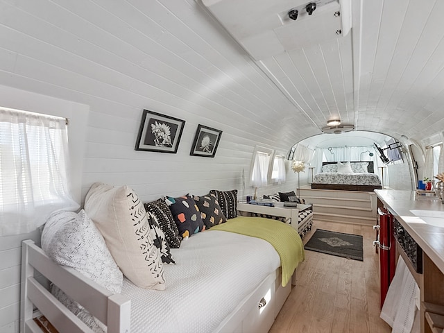 bedroom featuring vaulted ceiling and light wood-type flooring