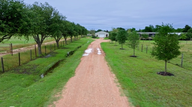 surrounding community with a rural view and a lawn