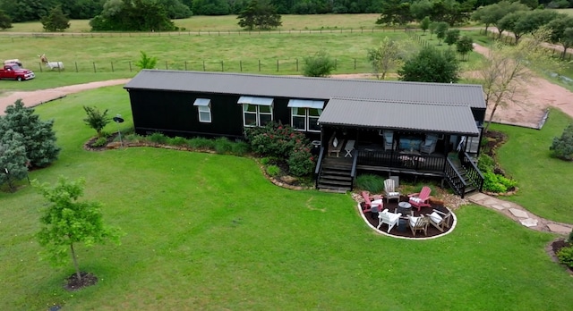 back of property featuring a yard and a rural view