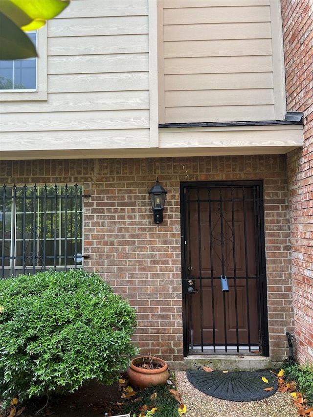 doorway to property featuring brick siding