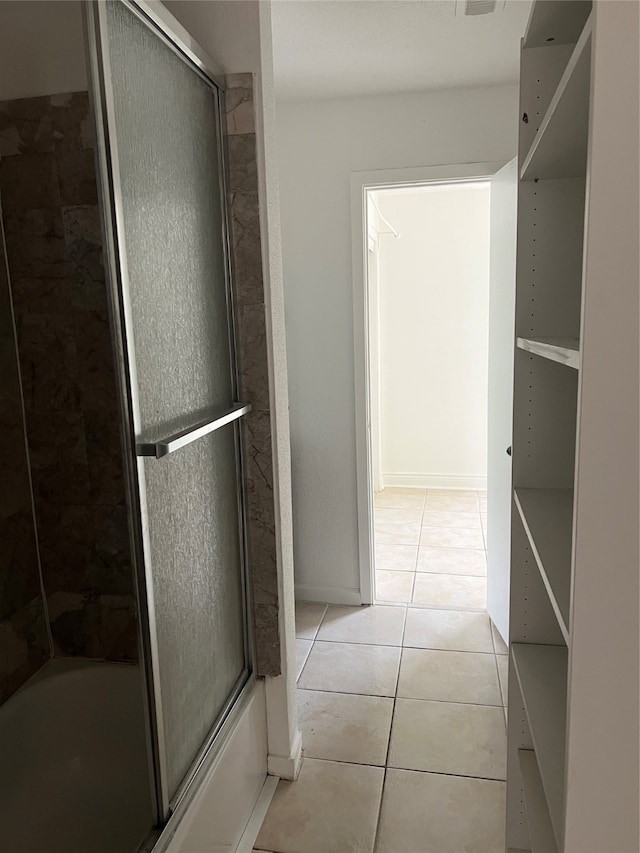 bathroom with tile flooring and shower / bath combination with glass door