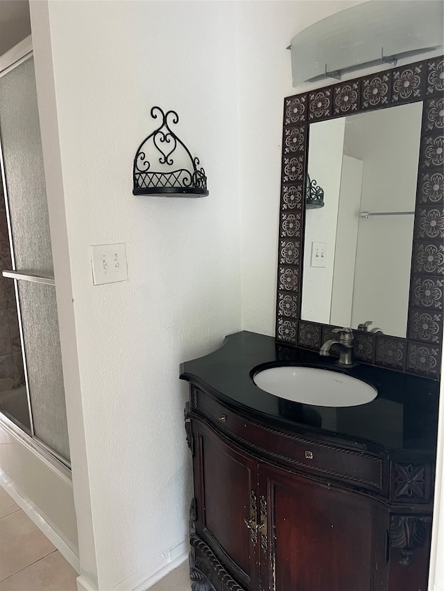 bathroom with tile flooring, combined bath / shower with glass door, and large vanity