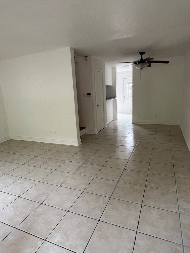 tiled spare room with ceiling fan