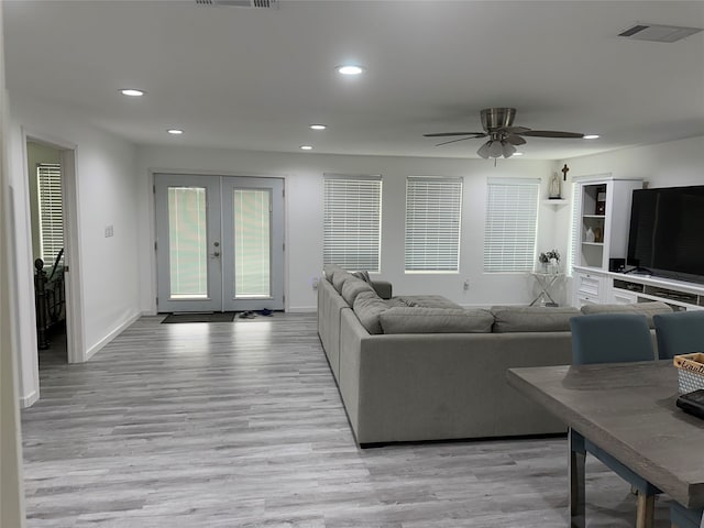 living room featuring french doors, light hardwood / wood-style floors, and ceiling fan