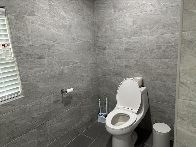 bathroom featuring tile walls and toilet