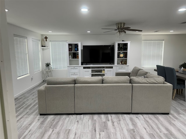 living room featuring light hardwood / wood-style floors and ceiling fan