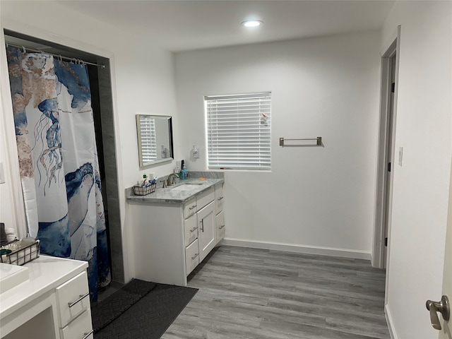 bathroom with hardwood / wood-style flooring and large vanity