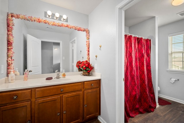 bathroom featuring toilet, vanity, and hardwood / wood-style floors