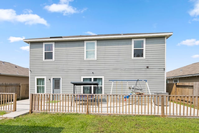 back of house with a lawn and a patio