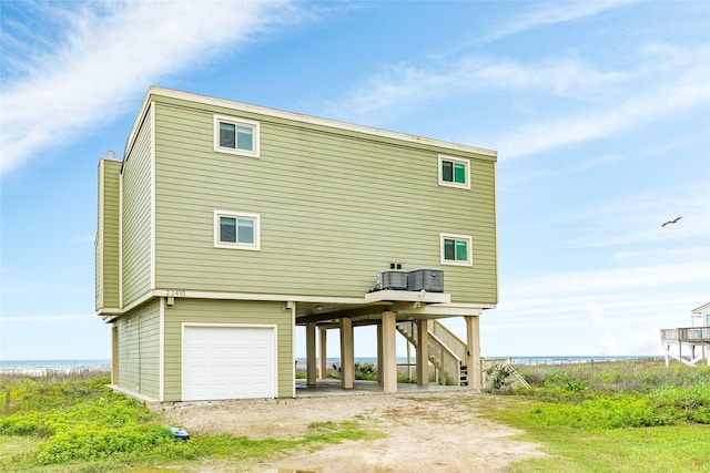 rear view of property with a garage and a water view