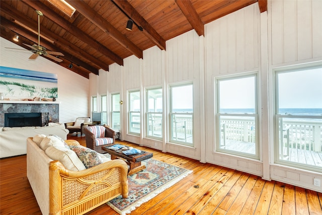 sunroom featuring wood ceiling, lofted ceiling with beams, and ceiling fan