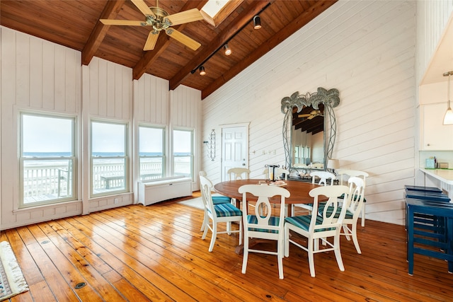 dining space featuring beamed ceiling, wooden ceiling, and light wood-type flooring