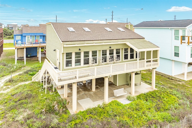 rear view of property featuring a wooden deck and a patio