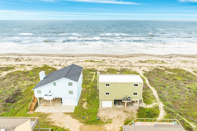 drone / aerial view with a water view and a beach view