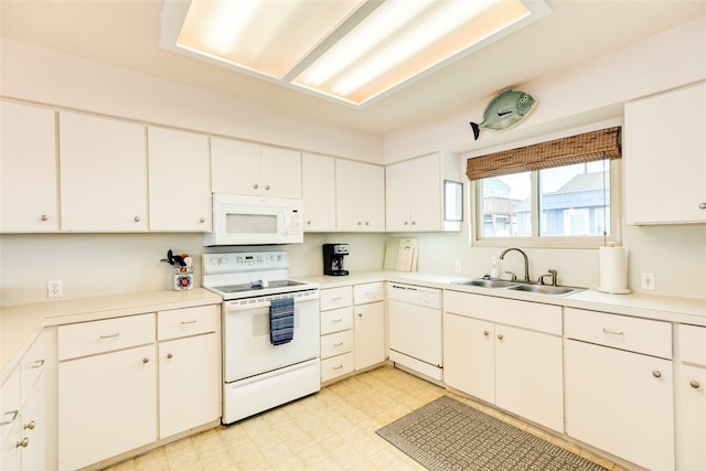 kitchen with white cabinets, white appliances, sink, and light tile floors