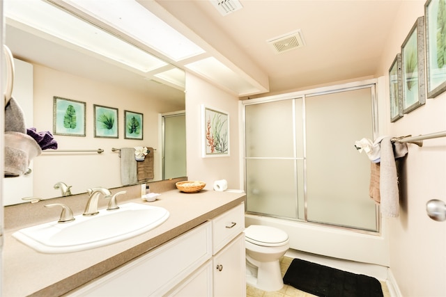 full bathroom with vanity with extensive cabinet space, toilet, tile floors, and combined bath / shower with glass door