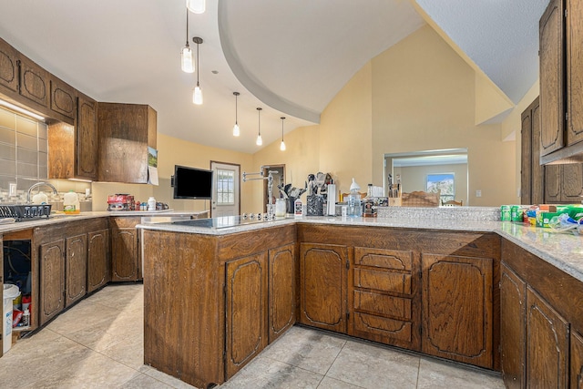 kitchen with a sink, a peninsula, light countertops, black electric cooktop, and lofted ceiling